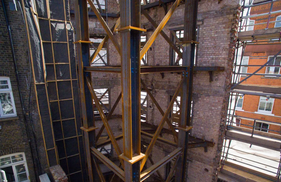 Steel facade retention system supporting a brick building